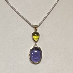 Peridot and amethyst cabochon pendant surrounded by 14 kt gold on a sterling silver 18 inch chain